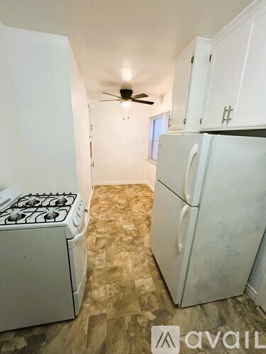 A kitchen with a white stove and refrigerator.