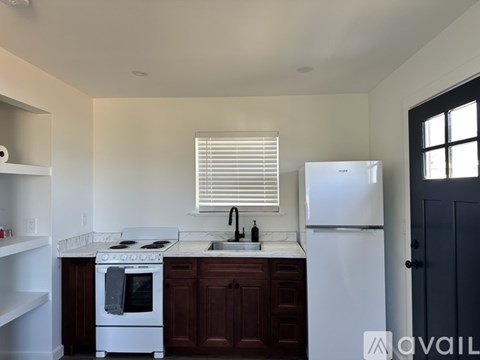 A kitchen with white appliances and brown cabinets.