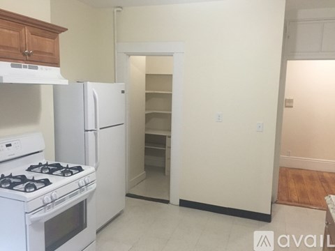 A kitchen with a white stove and refrigerator, and a doorway leading to another room.