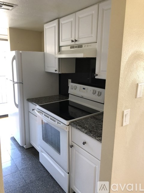 A kitchen with white appliances and cabinets.