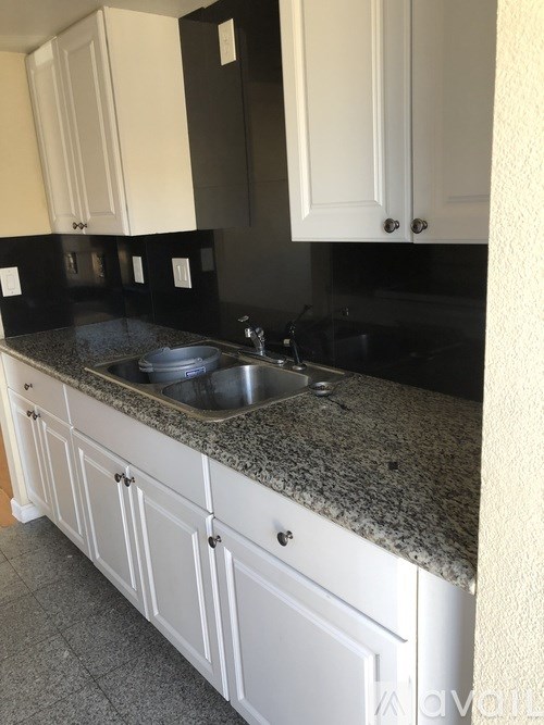 A kitchen with black countertops and white cabinets.
