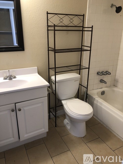A white toilet sits next to a white sink in a bathroom.