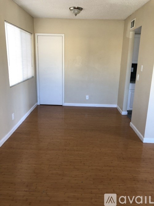 A room with wooden flooring and white walls.