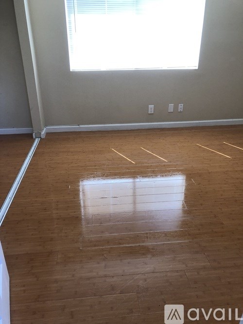 A room with wooden flooring and a window.