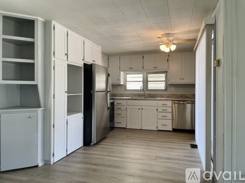 A kitchen with white cabinets and a stainless steel refrigerator.