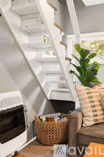 A living room with a couch and a basket on the floor.