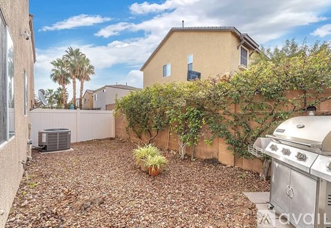 A backyard with a BBQ grill and a wall covered in greenery.