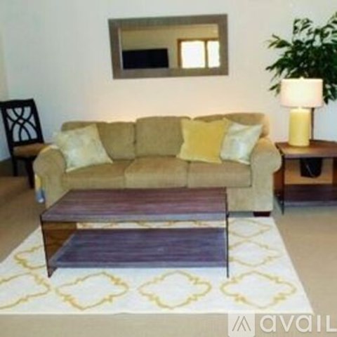 A beige couch with yellow pillows sits in a living room.