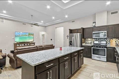 A modern kitchen with dark wood cabinets and stainless steel appliances.