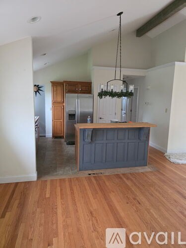 A kitchen with wooden floors and a grey island.
