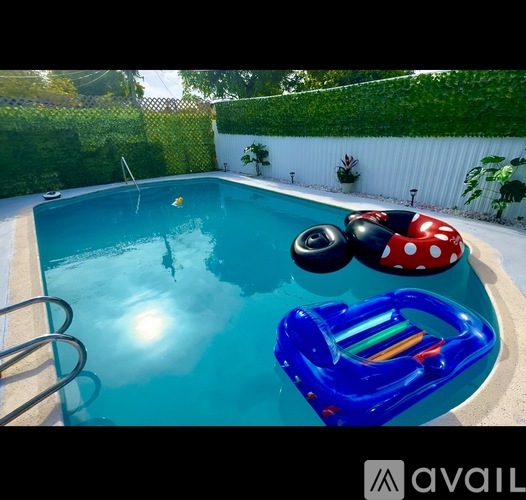 A small pool in a backyard with a house and a sunset in the background.