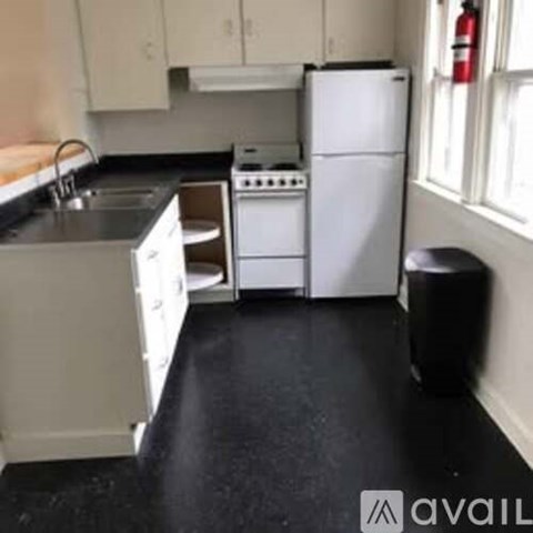 A kitchen with black countertops and white appliances.
