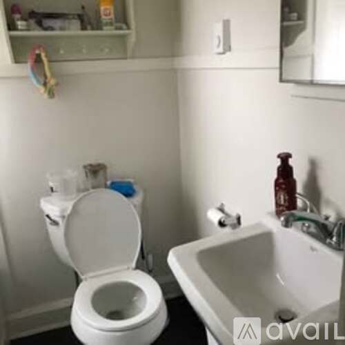 A white toilet is in a bathroom next to a sink.