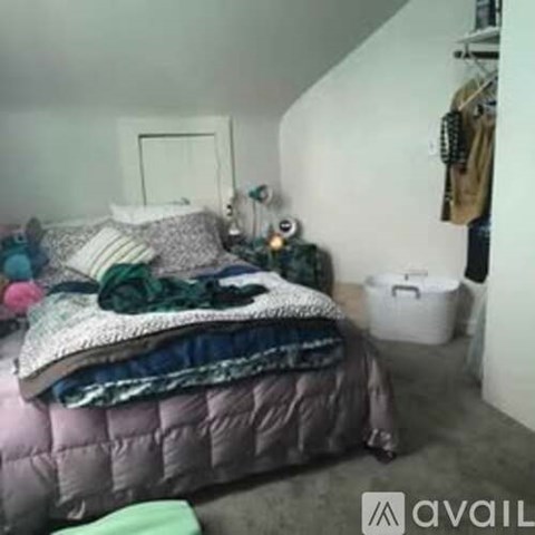 A bed with a pink cover and a white pillow is in the image.