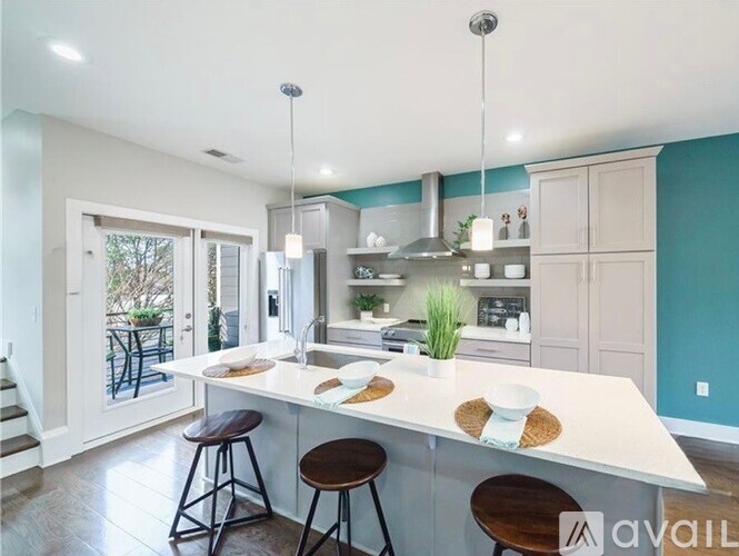 A kitchen with a white countertop and bar stools.