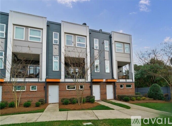 A modern apartment building with a brick base and grey upper floors.