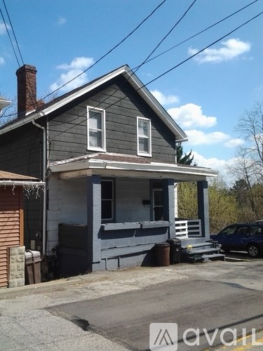 A two-story house with a grey exterior and a white porch.