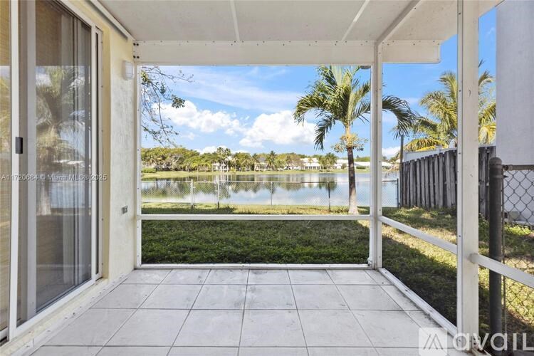 A balcony with a view of a lake and palm trees.