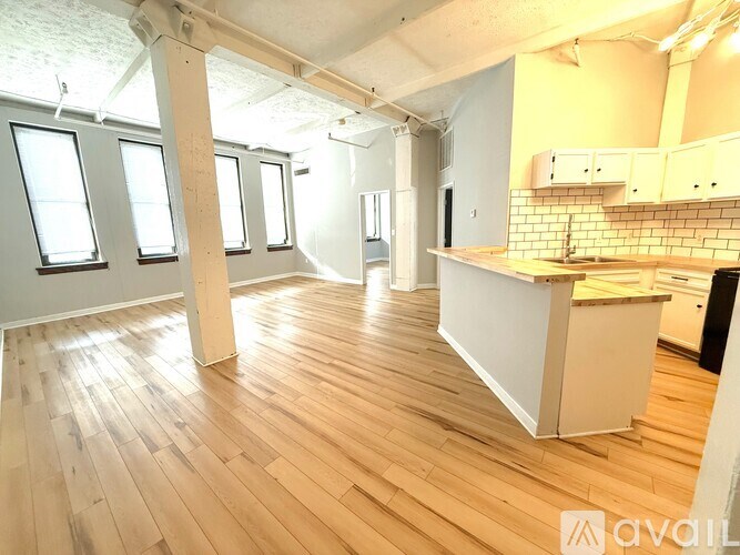 A kitchen with a white counter and wooden floors.