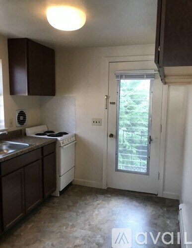 A kitchen with brown cabinets and a white stove top oven.
