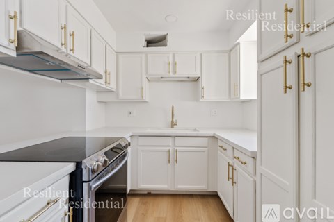 A kitchen with white cabinets and a black countertop.