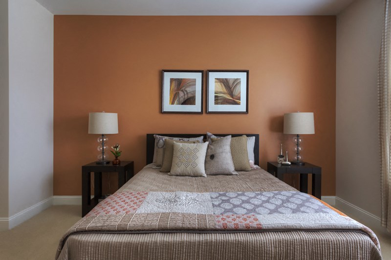 a bedroom with a bed and two pictures on the wall