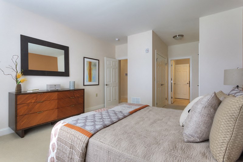 a bedroom with a bed and a dresser and a mirror