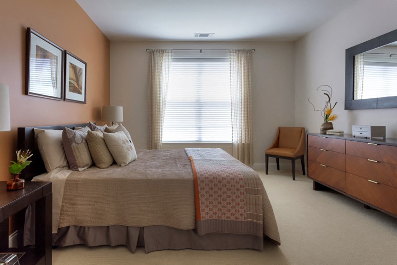 a bedroom with a bed and a dresser and a window