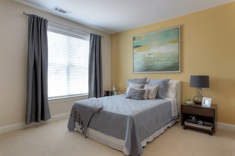 a bedroom with a bed and a painting on the wall