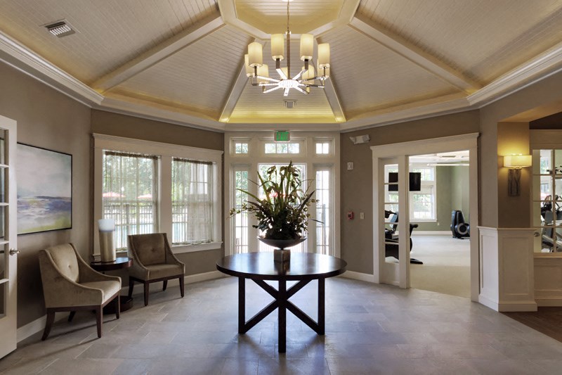 a lobby with a table and chairs and a chandelier