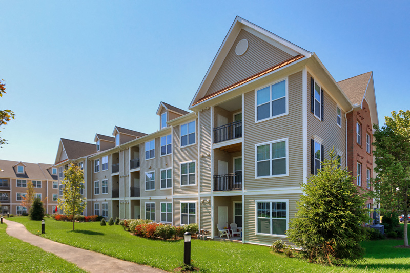 an apartment building with a sidewalk in front of it