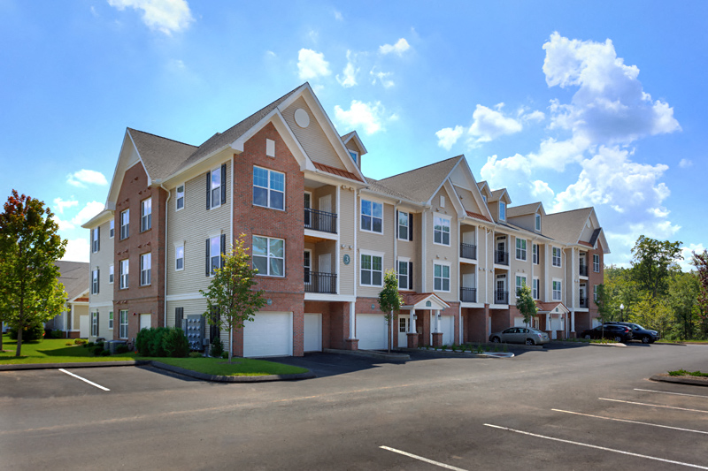 an apartment building with a parking lot in front of it
