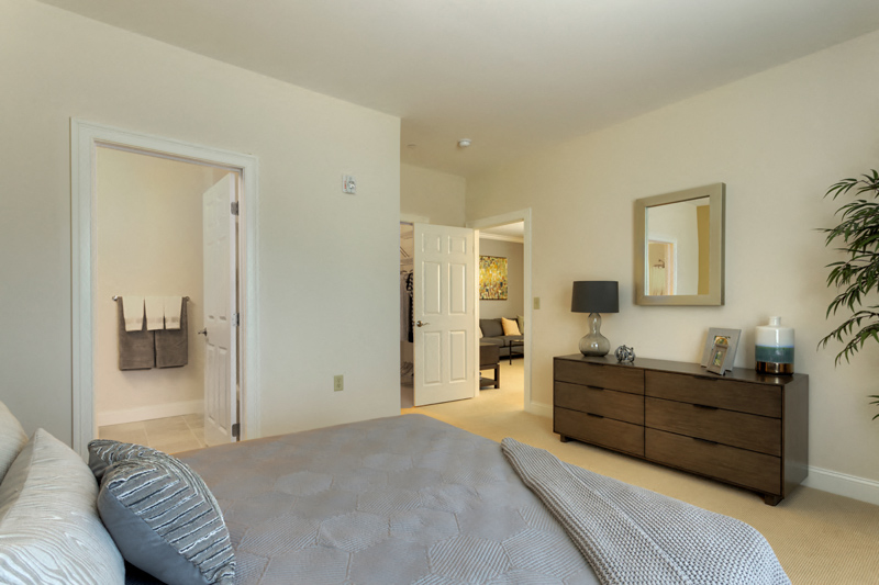 a bedroom with a bed and a dresser and a bathroom