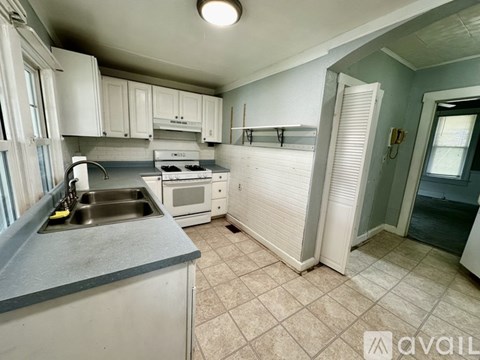 A kitchen with white cabinets and a sink.