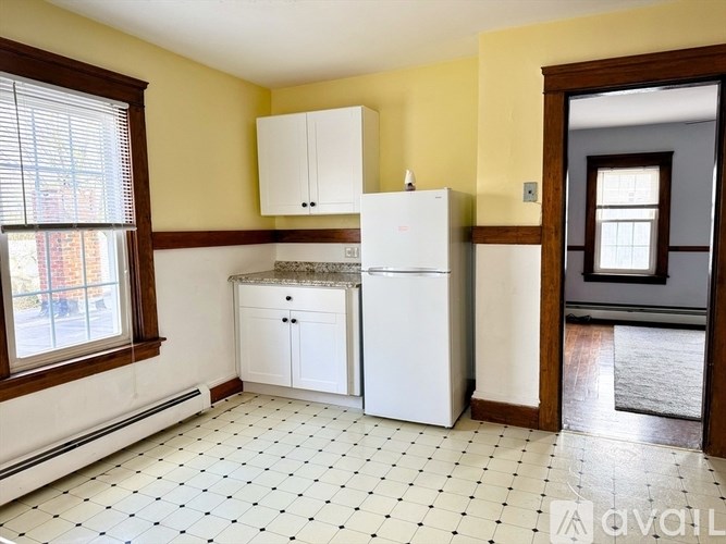 A kitchen with yellow walls and white appliances.