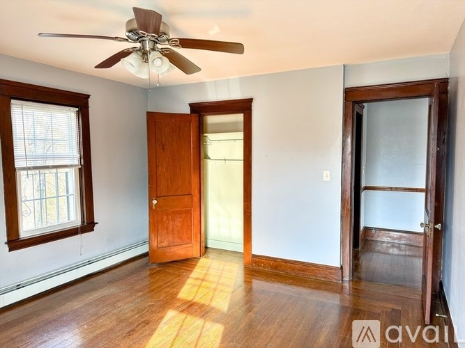 A room with a ceiling fan and wooden floors.