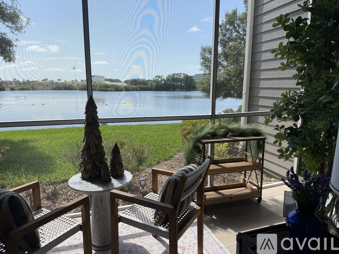 A patio with a table and chairs overlooking a lake.