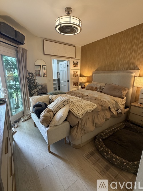 A bedroom with a large bed and a window with curtains.