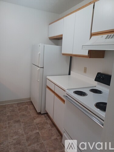 A kitchen with a white fridge and stove top oven.