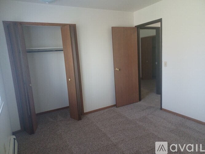 A room with a brown wardrobe and a white wall.