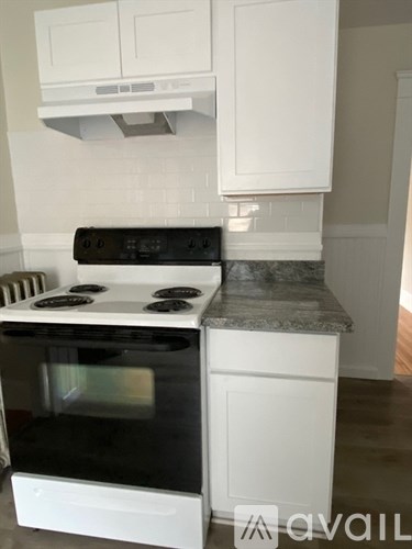 A white oven with a black stove top is installed into a counter top.