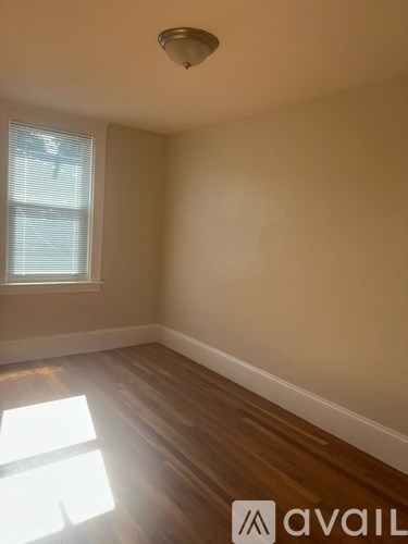 A room with a window and wooden floors.