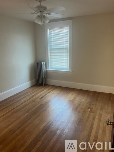 A room with a fan, window, and radiator.
