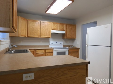 A kitchen with wooden cabinets and a white refrigerator.