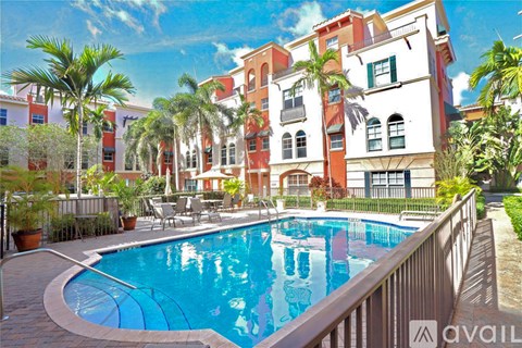 A pool surrounded by palm trees and chairs.
