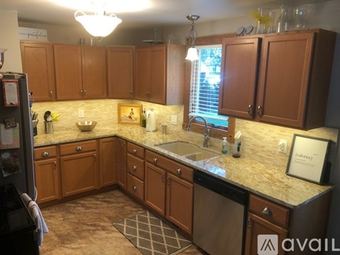 A kitchen with brown cabinets and granite countertops.