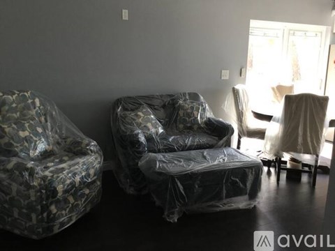 A living room with two chairs covered in plastic.