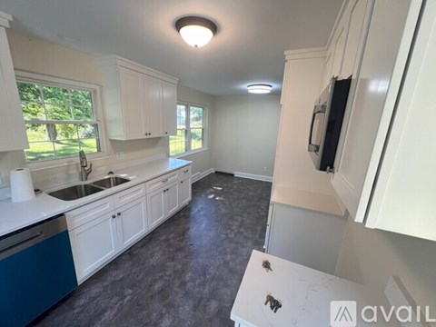 A kitchen with white cabinets and a blue drawer.