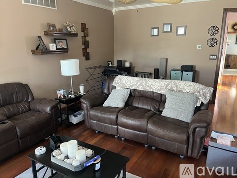 A living room with brown leather furniture and a white lamp.