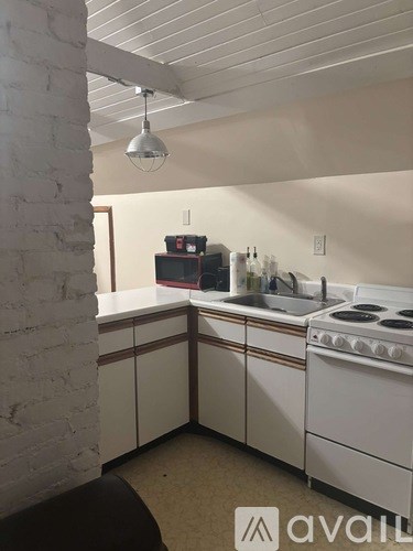 A kitchen with white cabinets and a stove top oven.